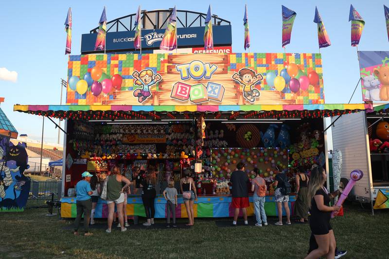 People line up at one of the many carnival game booths at the Taste of Joliet on Friday, June 21, 2024 at Joliet Memorial Stadium.