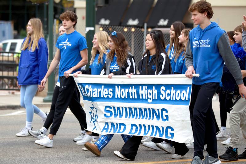 St. Charles North swimmers and divers walk during the school’s annual homecoming parade on Main Street through downtown St. Charles on Thursday, Oct. 19, 2023.