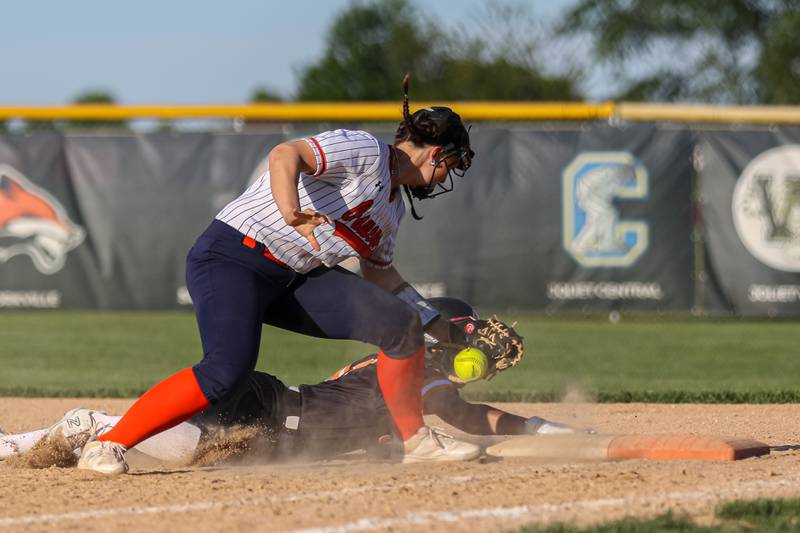 Wheaton-Warrenville South's Alli Michalowski (7)] slides back into first to beat the pickoff attempt during Class 4A Plainfield North Sectional semifinal softball game between Wheaton-Warrenville South at Oswego. May 29th, 2024.