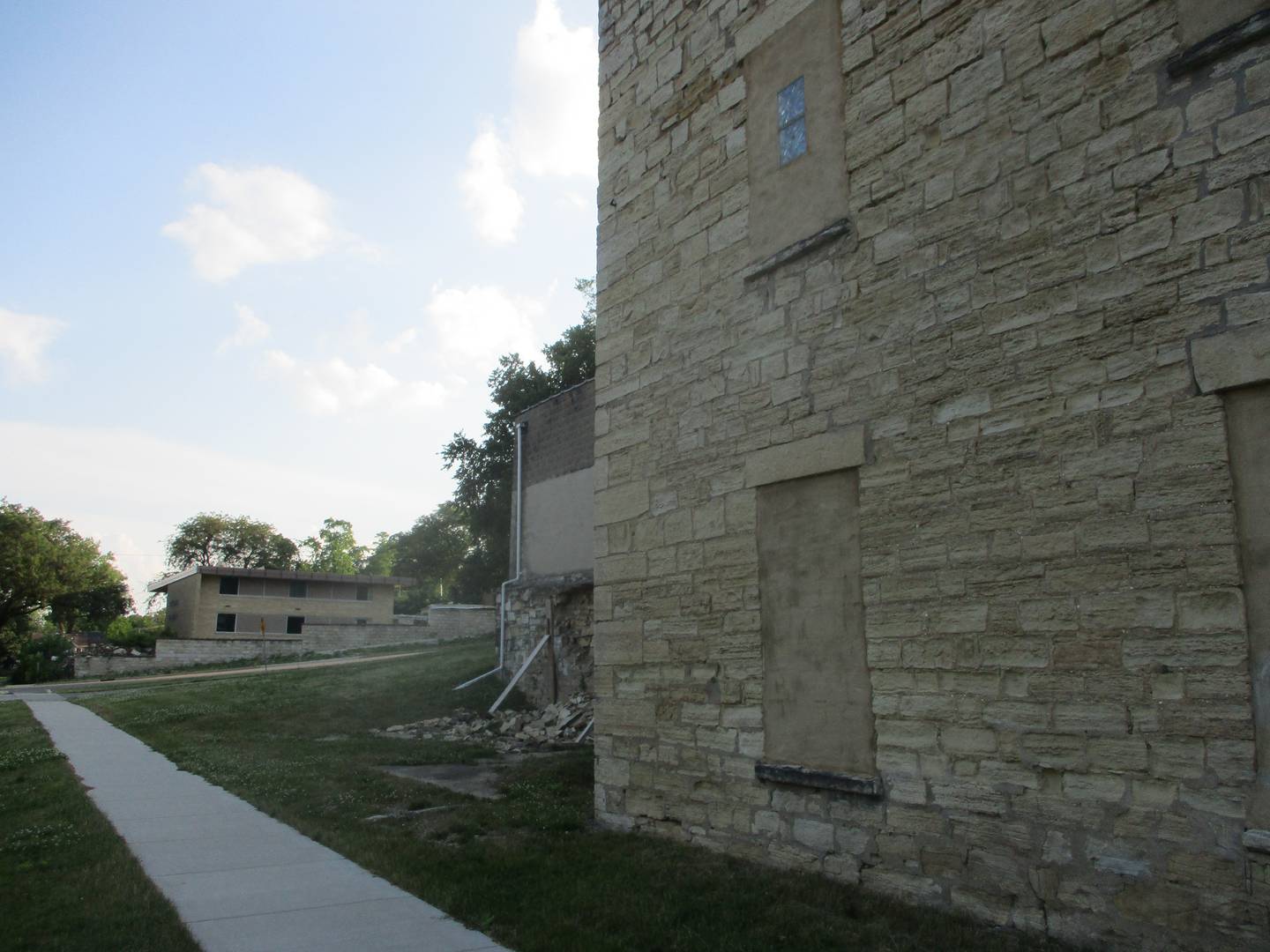 The old chancery building, which formerly housed offices for the Diocese of Joliet, can be seen in the background on the other side of Bridge Street from the former malt house that investors intend to convert into short-term rental units. Joliet, Illinois. June 17, 2024