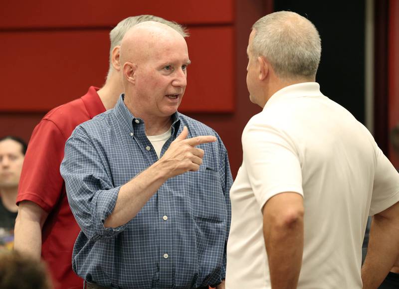 Dan Sears (front left) of D-N-J Properties, and owner of the building at 128 to 140 S. Second Street, along with his brother Joe Sears (back left) engage in a discussion with DeKalb Mayor Cohen Barnes (right) Monday, July 10, 2023, before the DeKalb City Council meeting. The city council has plans to consider acquiring and demolishing the 133-year-old building owned by Sears to provide space for additional downtown parking.