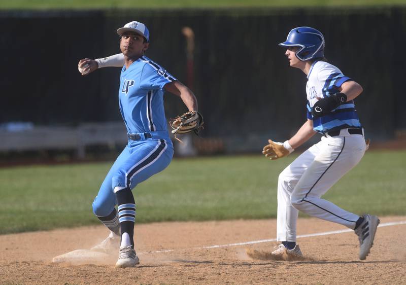 Lake Park's Jayden Patel, left, gets St. Charles North's Jaden Harmon out at thrid base during Friday’s baseball game in St. Charles.