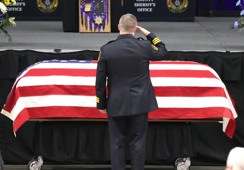 DeKalb County Sheriff Andy Sullivan salutes the flag-draped casket of colleague Deputy Christina Musil Thursday, April 4, 2024, during her visitation and funeral in the Convocation Center at Northern Illinois University. Musil, 35, was killed March 28 while on duty after a truck rear-ended her police vehicle in Waterman.