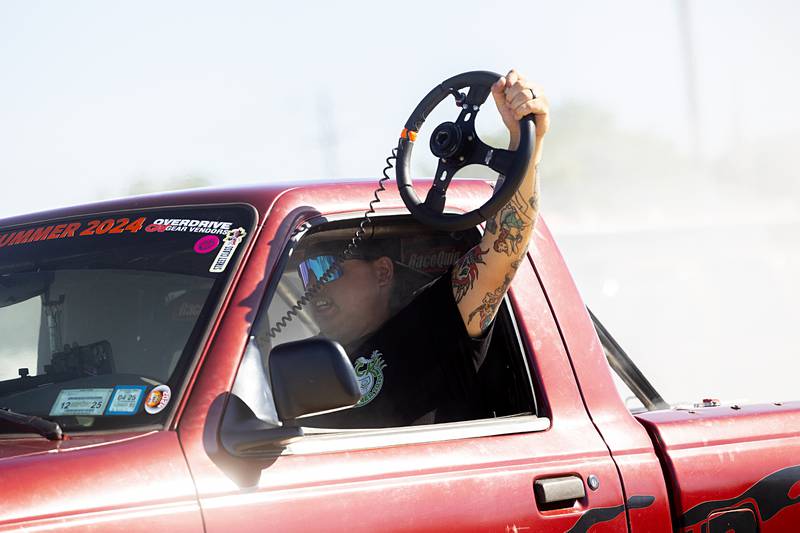 The first burn-out competitor of the day shows off his skills by releasing the steering wheel Monday, June 10, 2024.