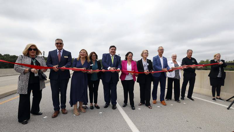 The ribbon cutting for the long-awaited opening of Long Meadow Parkway over the Fox River takes place Thursday, Aug. 29, 2024 in Algonquin with dignitaries including Illinois Gov. JB Pritzker, center.