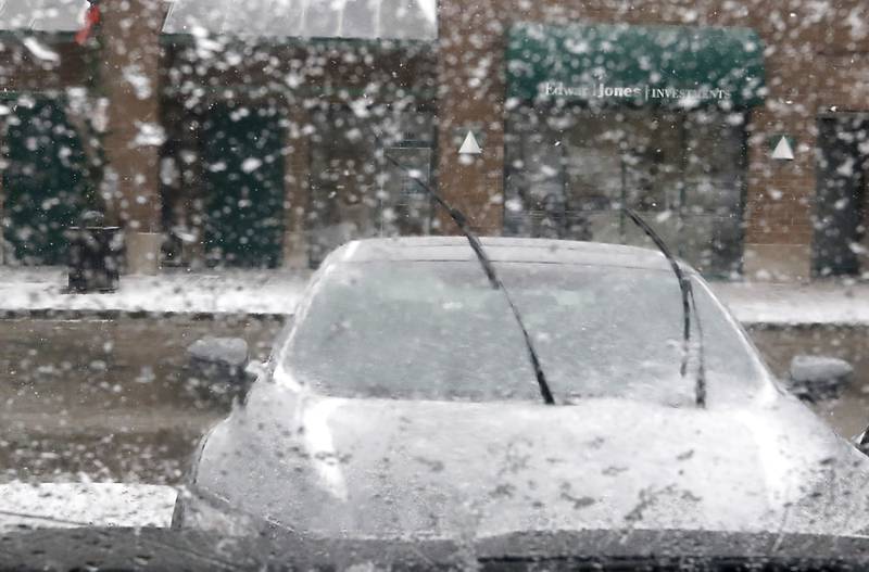 Windshield wipers are lifted to make the snow easier to remove from a car parked in downtown Crystal Lake on Thursday, Dec. 22, 2022, as a winter storm hits northern Illinois.