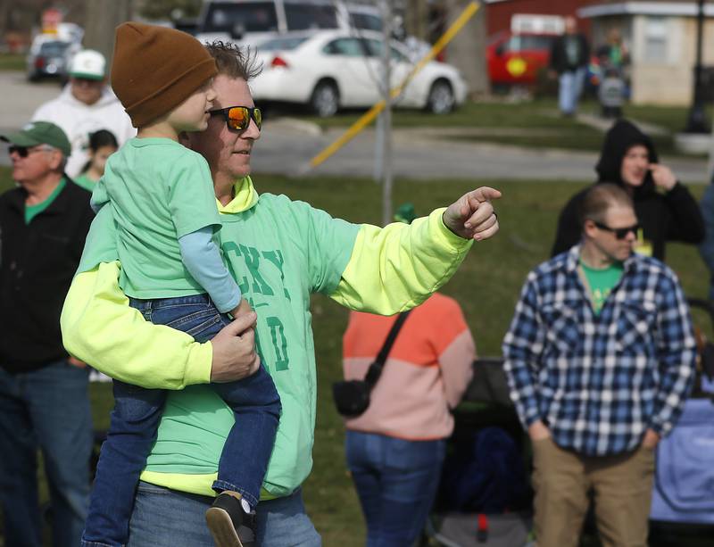 A father and son watch as the Fox River is dyed green during the ShamROCKS the Fox Festival in McHenry on Saturday, March 16, 2024.