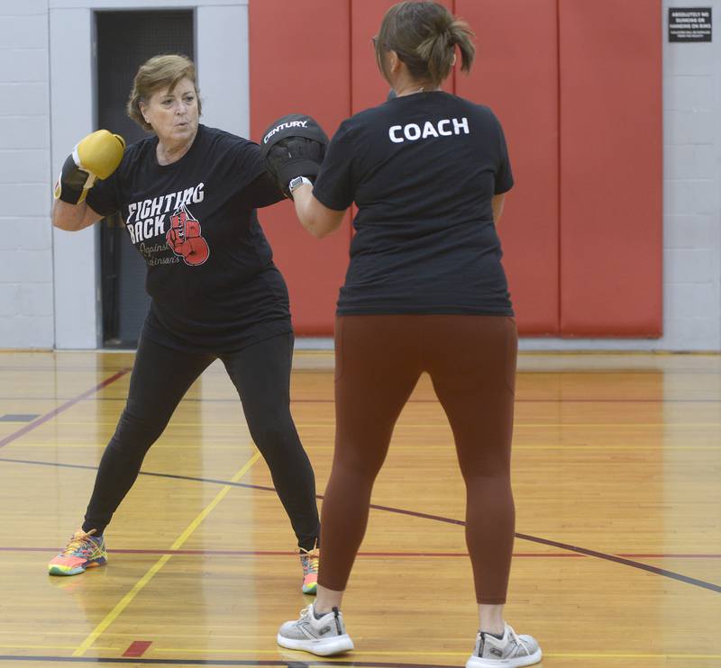 Elaine McKinney rears back for a punch during her Rocksteady Boxing course with trainer Nichole Reynolds at the Streator YMCA.