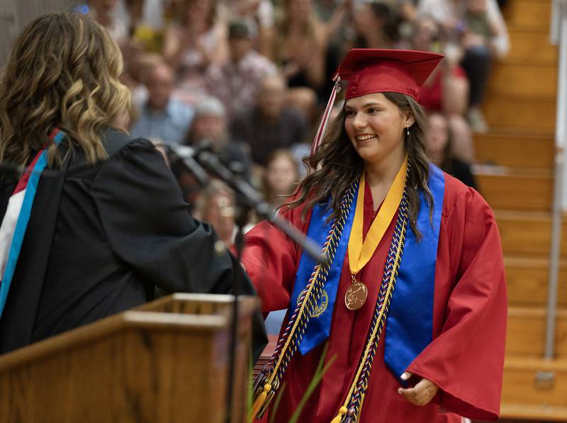 Class Valedictorian Abby Mascal receives a scholarship Sunday, May 19, 2024, honoring her achievement during Streator High School's commencement ceremony. The award is presented by school principal Amy Jo Lotshaw, who also is Mascal's mother.