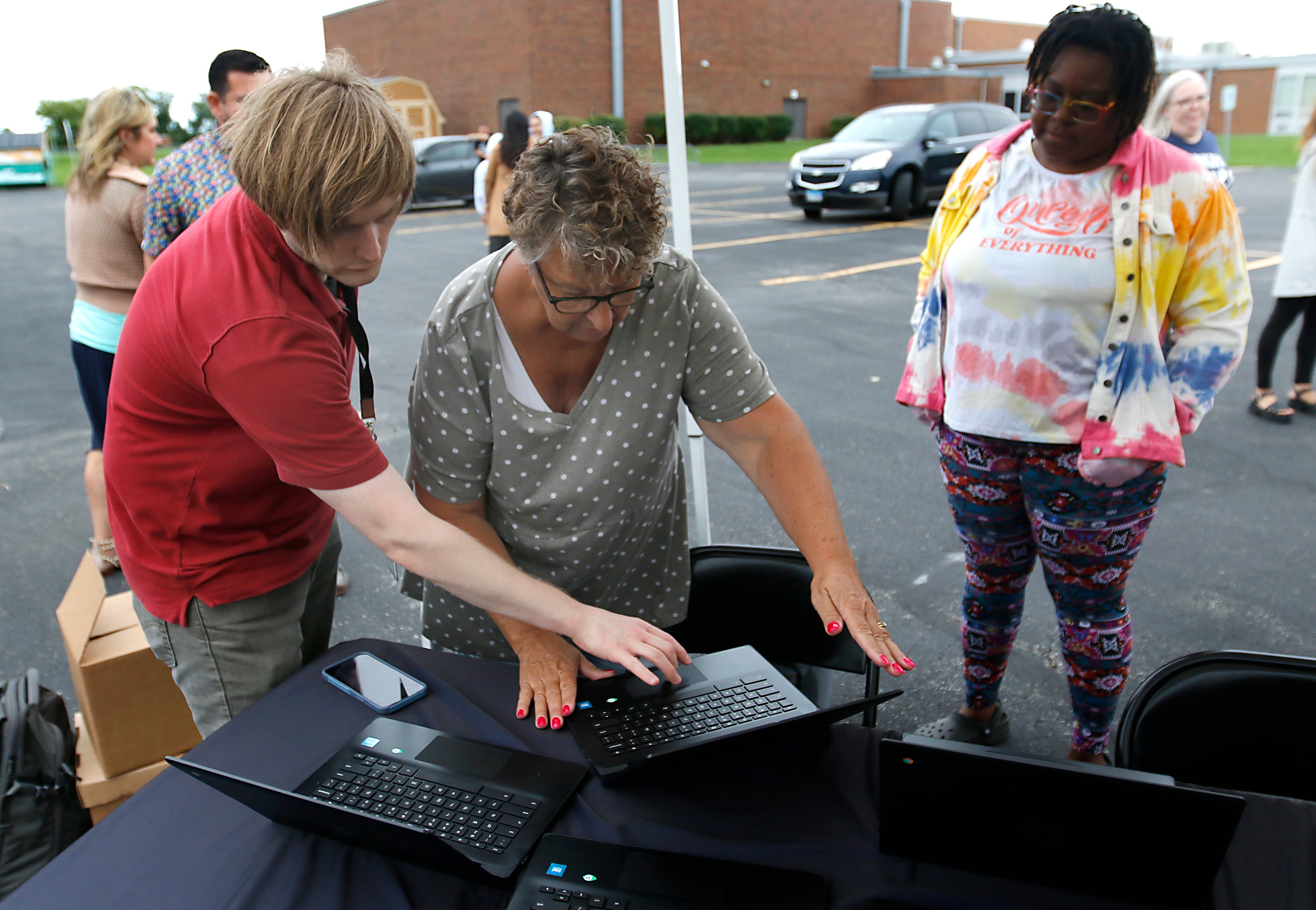 John Kowalewski and Cathy Buhrow work on a computer during a Woodstock School District 200 Back to School Coming to You event at Northwood Middle School on Tuesday, Aug. 6, 2024. The location was one of twelve stops on the tour that gave out backpacks and school supplies, provided registration help and computer repair.