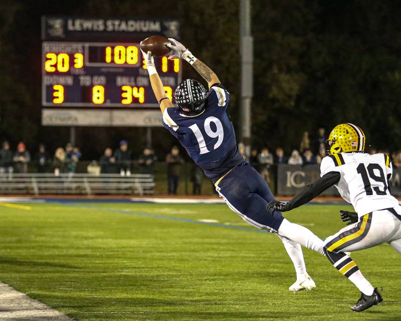 IC Catholic Prep's Eric Karner (19) reaches for a sideline catch to convert a first down during Class 4A third round playoff football game between St Laurence at IC Catholic Prep.  Nov 11, 2023.