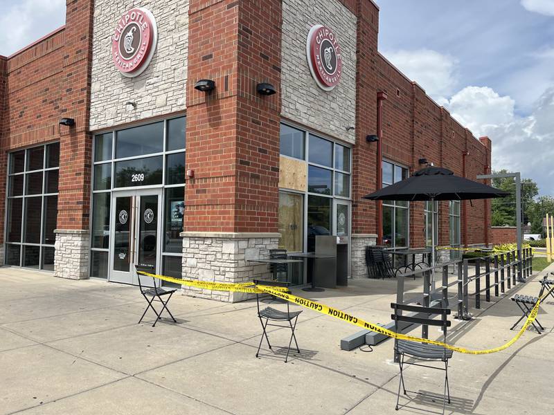 Police tape surrounds the patio of the Chiptole restaurant on Jefferson Street in Joliet after a pole was knocked through the window by vehicle fleeing police.