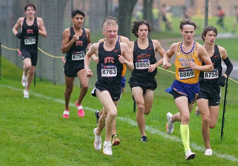 St. Charles East’s Jedidiah Wilson (8763) and Wheaton North’s Quinn Murphy (8869) lead the pack in the first leg of the Dukane Conference Cross Country Championships at Lake Park High School in Roselle on Saturday, Oct. 14, 2023.