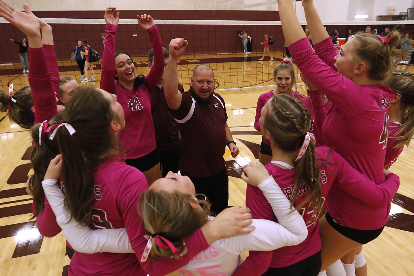 Richmond-Burton Head Coach Mike Kamholz leads his team in a celebration for winning the Kishwaukee River Conference title after defeating Woodstock North in a  conference volleyball match Wednesday, Oct.11, 2023, at Richmond-Burton Community High School.