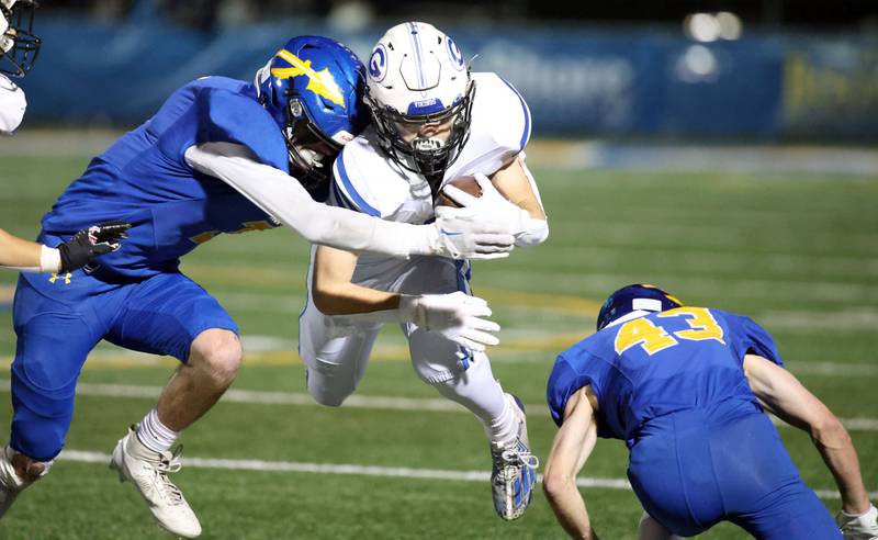 Geneva's Michael Rumoro (20) is hit by Lake Forest's Thomas Aberle (7) during the IHSA Class 6A playoff game Friday November 3, 2023 in Lake Forest.