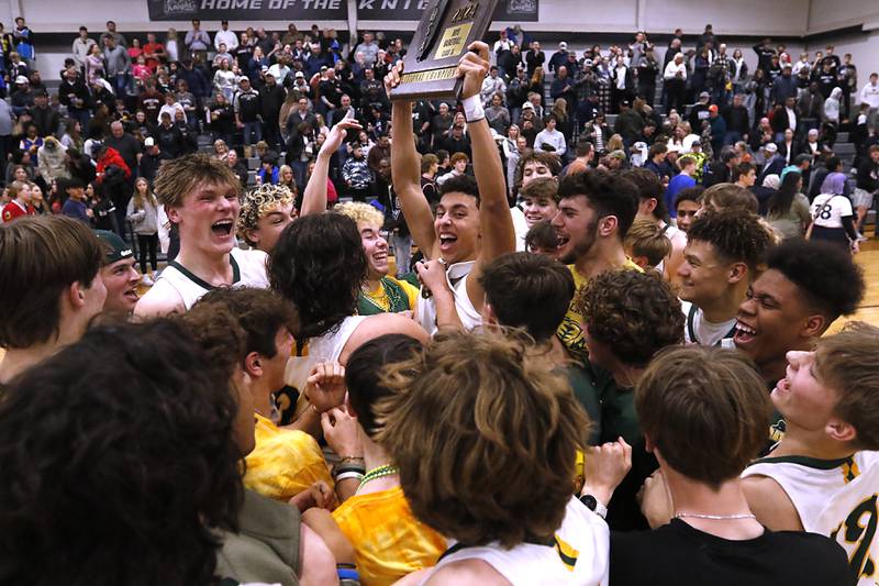 Crystal Lake South's AJ Demirov raises the championship trophy as players and fans celebrate Souths win over Kaneland in the IHSA Class 3A Kaneland Boys Basketball Sectional championship game on Friday, March 1, 2024, at Kaneland High School in Maple Park.