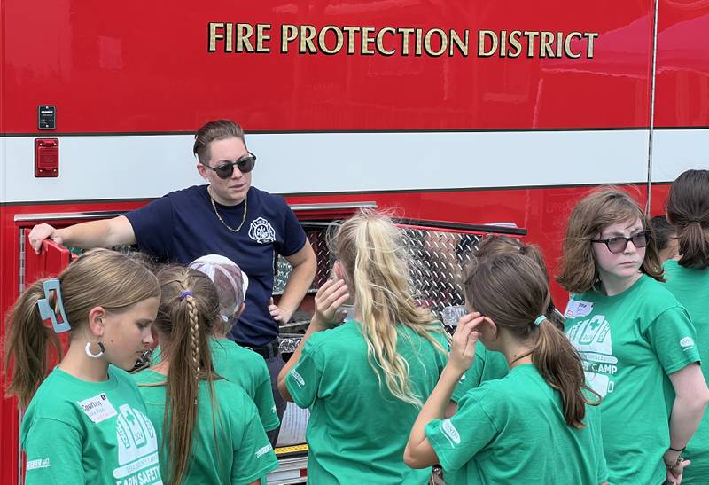 Alyssa McLaughlin, with the Malta Fire Protection District, talks to DeKalb County Farm Bureau Farm Safety campers at Jonamac Orchard on June 19, 2024.