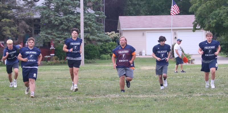 Members of the Fieldcrest football team sprint down the field while working on drills on Monday, July 8, 2024 at Fieldcrest High School.