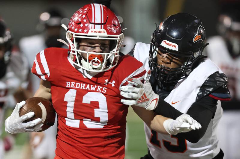 Naperville Central's Aiden Clark tries to get away from DeKalb’s Davon Grant during their game Friday, Oct. 6, 2023, at Naperville Central High School.