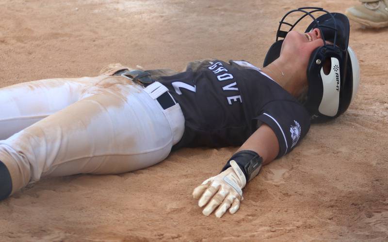 Cary-Grove’s Aubrey Lonergan collapses in celebration on home plate after legging out an inside-the-park home run against Burlington Central in varsity softball at Cary Monday.