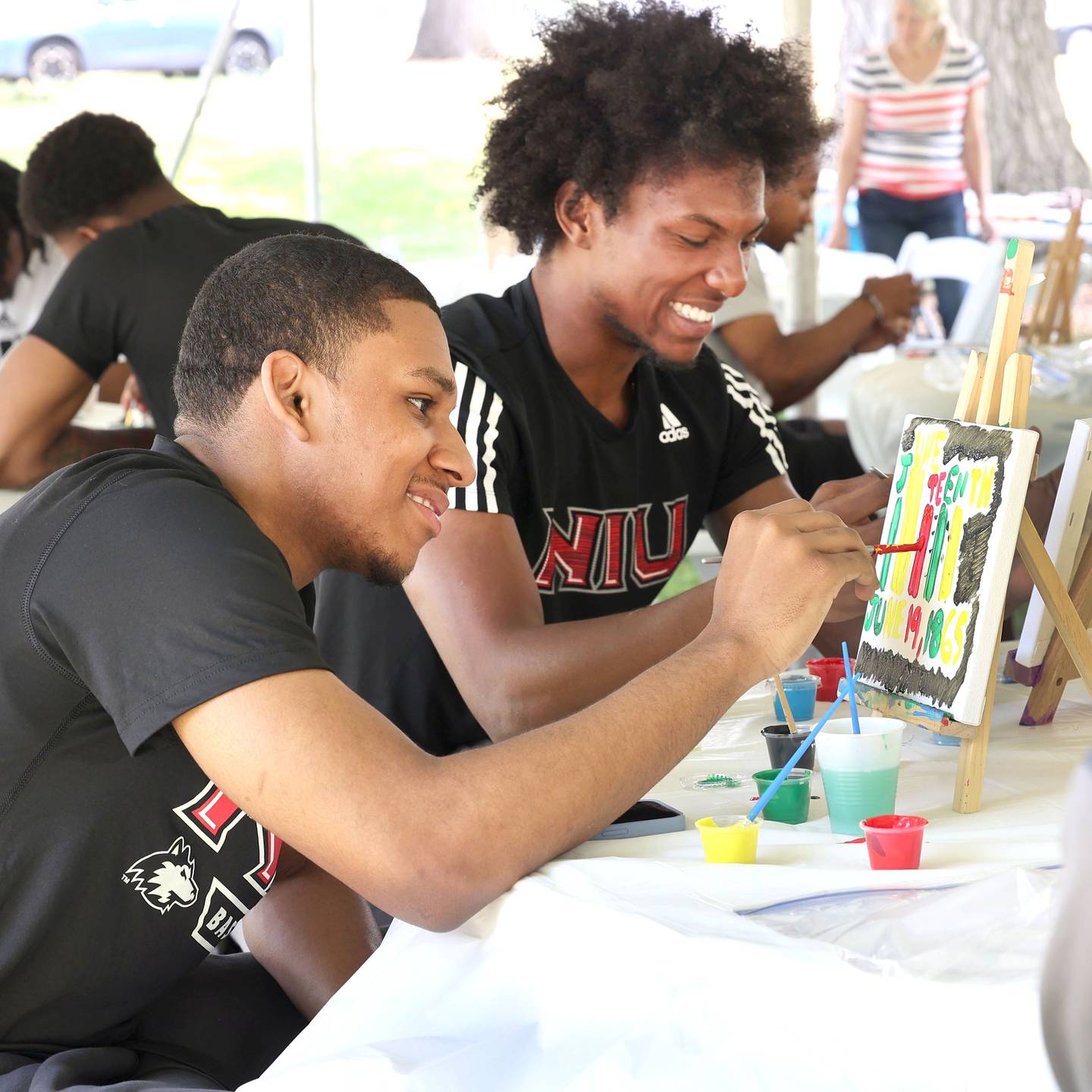 Northern Illinois University basketball players Nas Muhammad, (left) from Brooklyn, New York, and Zion Russell, from Upper Marlboro, Maryland, paint some Juneteenth themed artwork during the Juneteenth Community Celebration Sunday, June 18, 2023, at Hopkins Park in DeKalb. The event featured vendors, food, music, games, and more.