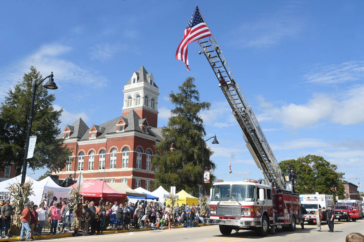The Oregon Fire Department raises the flag at the start of the 2022 Harvest Time Parade during the 51st Autumn on Parade festival in downtown Oregon.