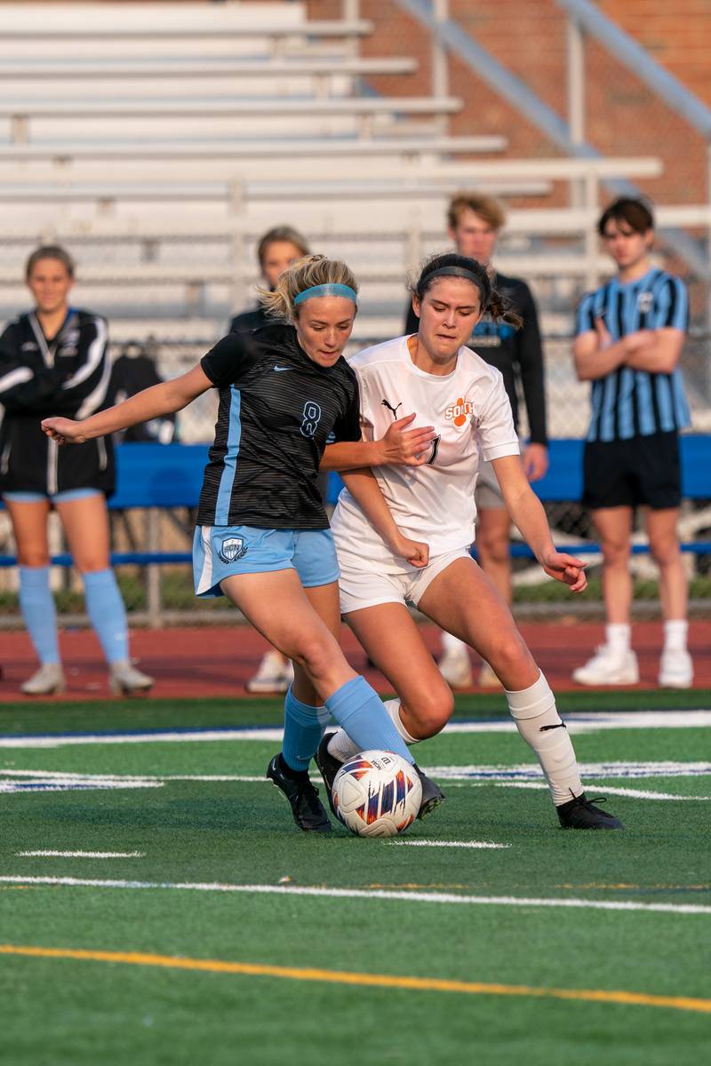 St. Charles North's Keira Kelly (8) plays the ball against Wheaton Warrenville South's Ella Byrnes (11) during the Class 3A girls soccer regional final at St. Charles North High School on Friday, May 19, 2023.