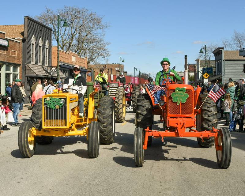 A line of old tractors roll down the St. Patrick’s parade route in downtown Lemont on Sunday March 9, 2024.