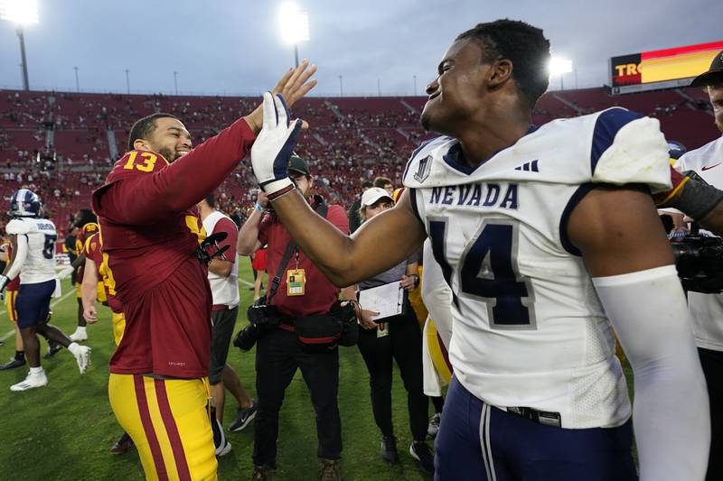 Southern California quarterback Caleb Williams (13) high-fives Nevada wide receiver John Jackson III (14) after a 66-14 win over Nevada in an NCAA college football game in Los Angeles, Saturday, Sept. 2, 2023. (AP Photo/Ashley Landis)