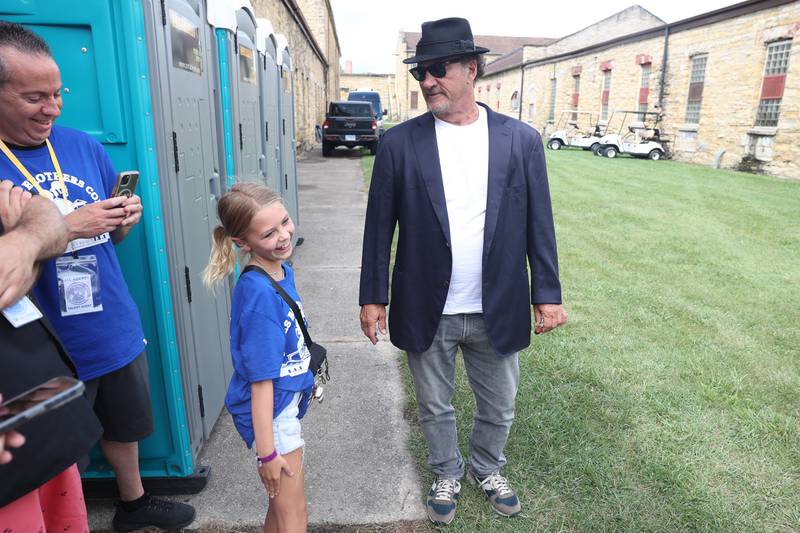 Lauren Armington, left, poses as a reporter and asks Jim Belushi if he is famous before his performance at Blues Brothers Con: The Sequel on Saturday, Aug. 17, 2024 at the Old Joliet Prison.Prison.