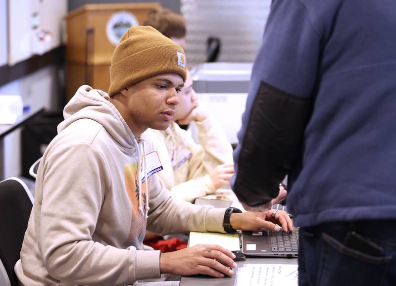 Kamaran Stringer, an election judge, checks in a voter Tuesday, March 19, 2024, in the polling place at the DeKalb County Administration Building in Sycamore.