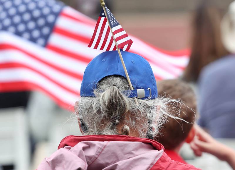 An attendee wears a flag as he listens to speakers Monday, May 27, 2024, during the DeKalb Memorial Day program at Ellwood House.