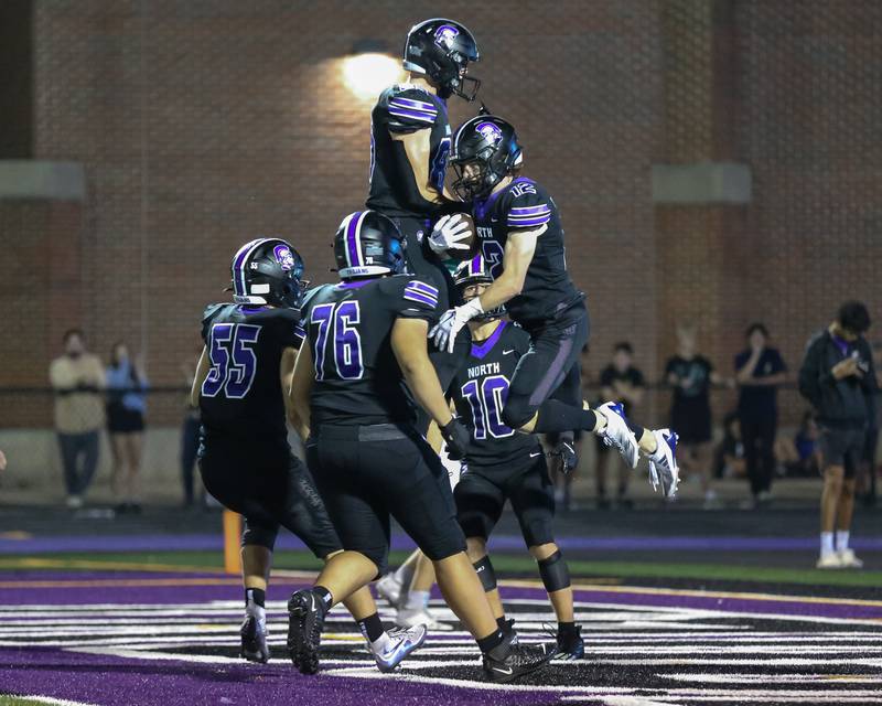 Downers Grove North's Max Troha (12) celebrates a touchdown reception with teammates during a football game between Glenbard West at Downers Grove North on Friday, Sept 13th, 2024  in Downers Grove.