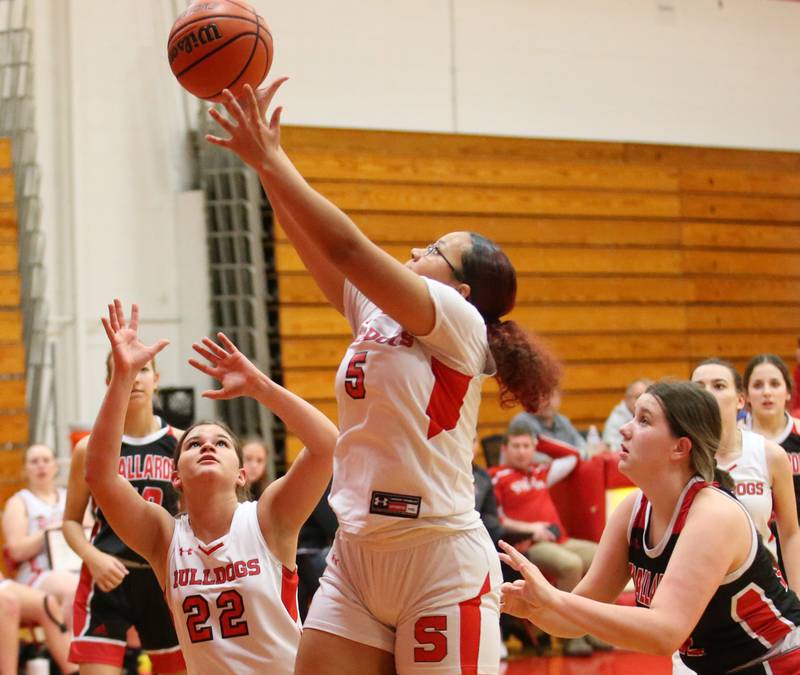 Streator's Jade Williams (center) grabs a rebound over Henry-Senachwine's Harper Schrock (right) on Wednesday, Jan,. 4, 2023 at Streator High School.