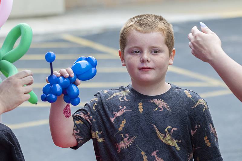 Liam Lyster, 8, of Dixon takes his poodle from artist Chris Busker on Saturday, June 8, 2024, at the Summer Block Party in Dixon. Hosted by My Play Village, Pam’s Hallmark & Fresh Finds, Culver’s, and Discover Dixon, and presented by Raynor Garage Doors, the party featured booths and fun for kids of all ages.