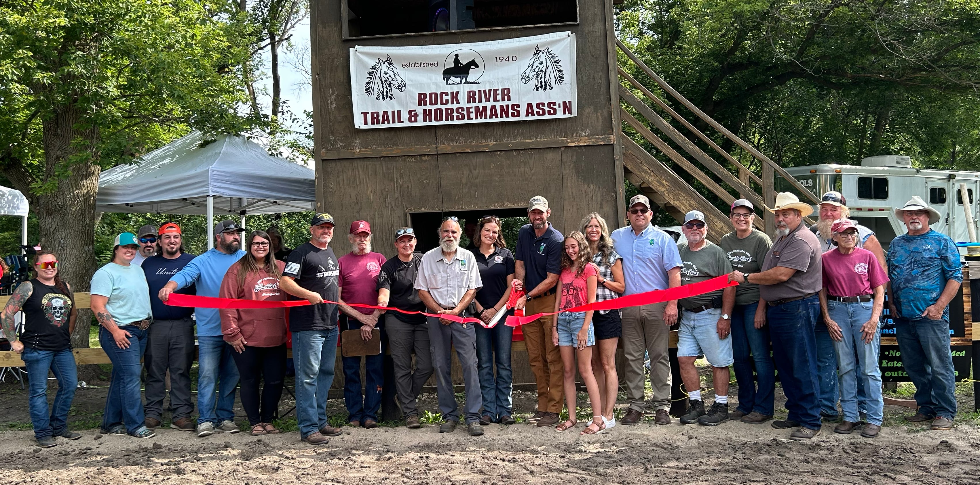 Franklin Creek State Park Site Superintendent Matt Hoogerwerf cuts the red ribbon as he poses with other dignitaries and members of the Rock River Trail & Horseman Association during the Grand Opening Show of the new Franklin Creek Arena on Saturday, July 20, 2024. The newly refurbished horse arena is located in Franklin Creek Natural Area, just north of Franklin Grove. It was completed through a cooperative effort between state park staff, volunteers from the RRTHA and donations from area businesses.