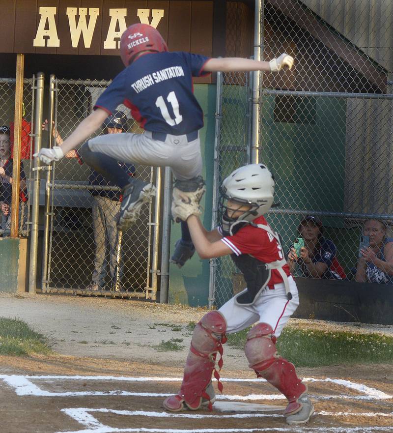 The Red Sox’s Landin Nickels (11) leaps in the air trying to avoid the tag of Angles catcher Ryder Harsted, but is called out at home in the first inning Friday, June 21, 2024, during the city championship game Friday in Ottawa.