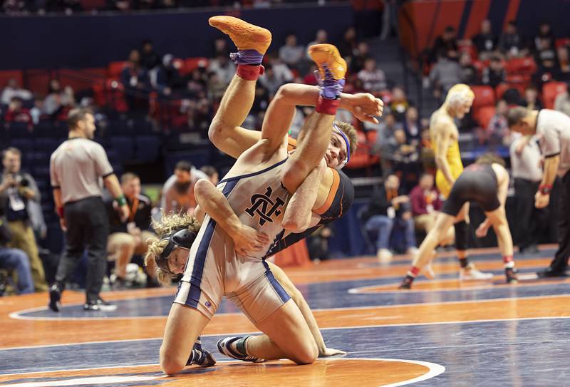 Sterling Newman Central’s Brady Grennan flips Richland’s Carson Bissey in the 132 pound 1A third place match Saturday, Feb. 17, 2024 at the IHSA state wrestling finals at the State Farm Center in Champaign.