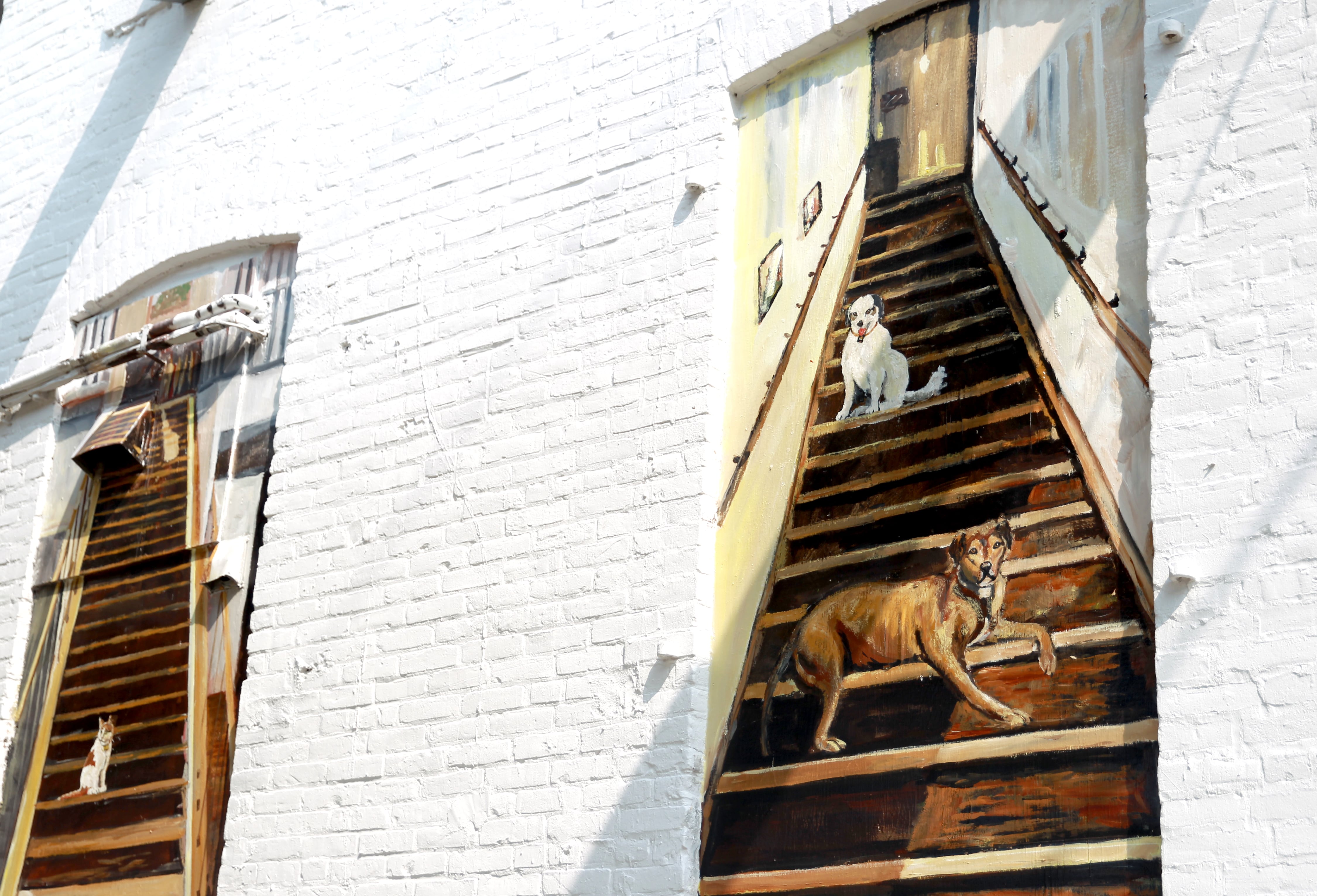 Artist Chris Cudworth used his two rescue dogs, Lucy and Crash, as models for a mural he painted on the backside of the Fox.Build Makerspace building in downtown St. Charles.