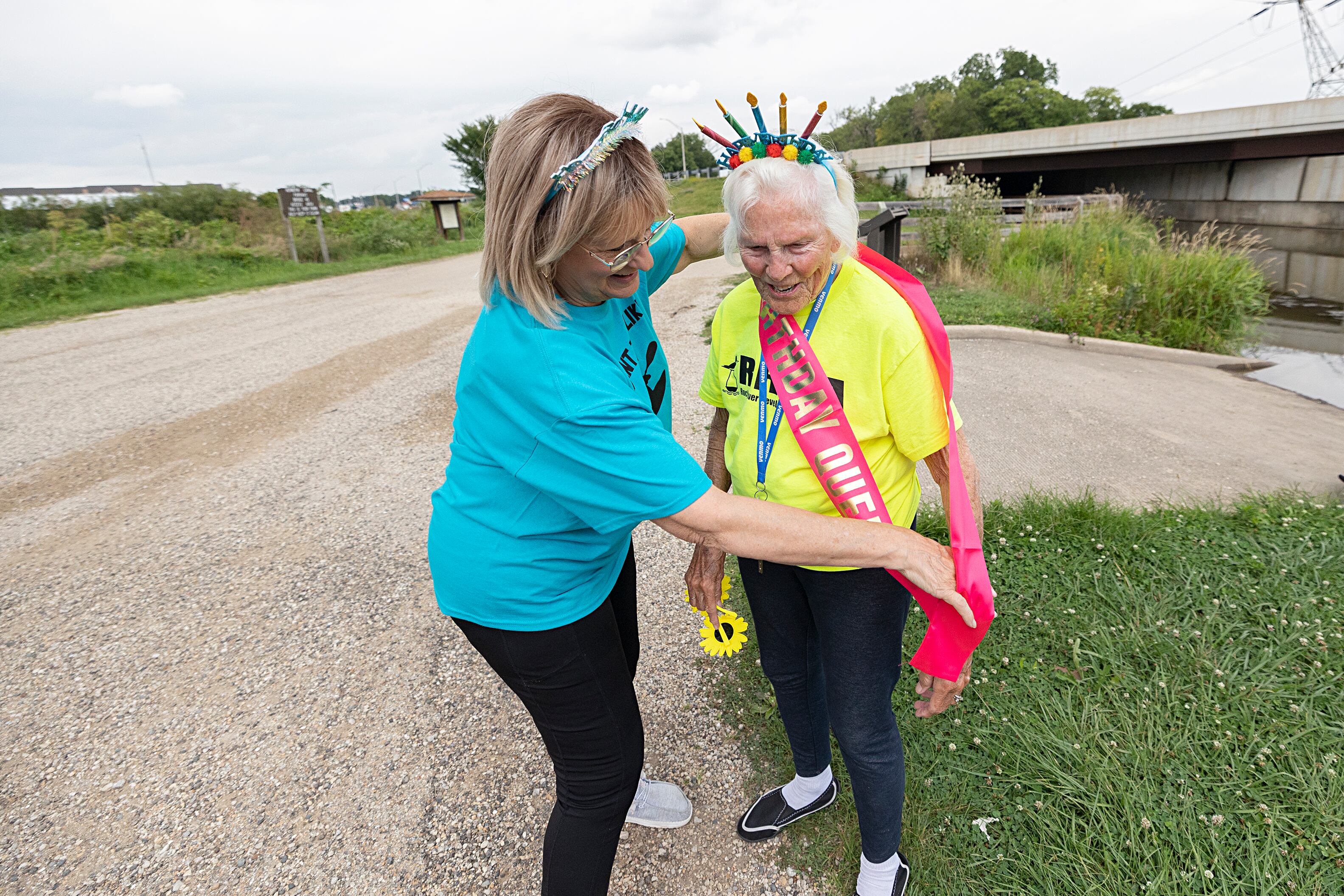 Teri Jahn sashes Nancy Gates as the “Birthday Queen” on Wednesday, July 24, 2024, before the Yak-Yak Sisters head out on the canal for their weekly float.