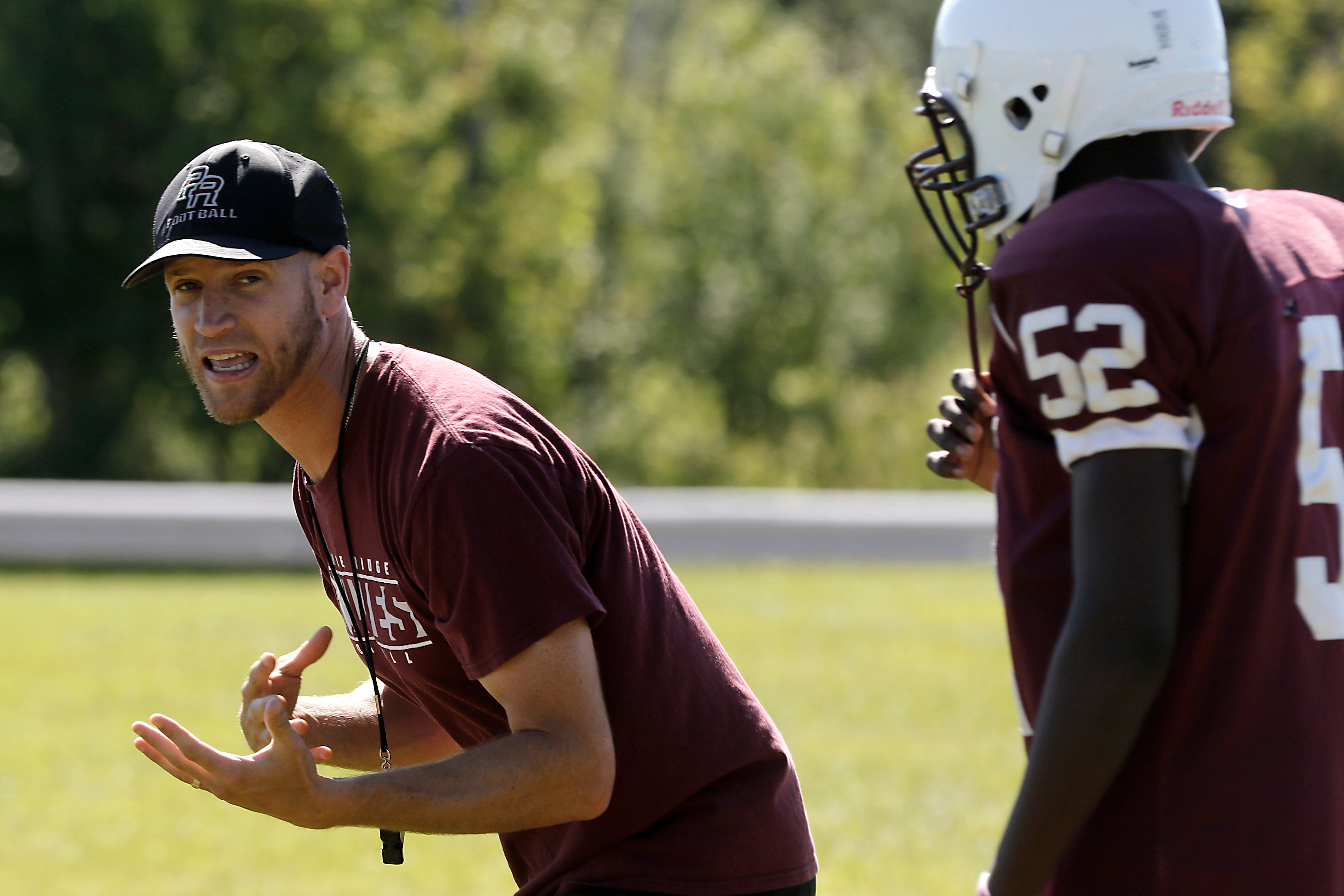 Prairie Ridge Head coach Michael Frericks explains how he wants a plays to block during football practice in July 2024, at Prairie Ridge High School .