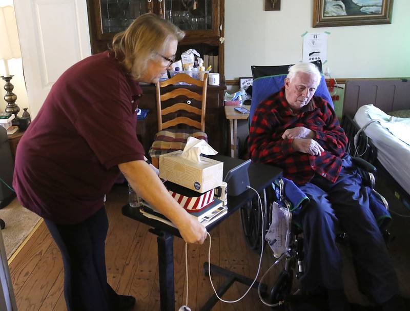 Marjo Gunnison, a home caregiver with Home Instead, helps move Joseph Seminara, 89, to another room in his Wonder Lake home on Friday, Feb. 10, 2023.