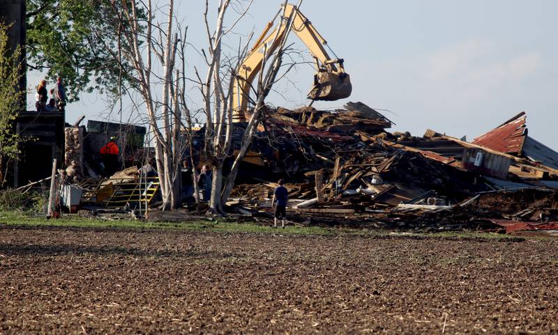 First responders and property owners tend the scene of a barn collapse along Weidner Road near Harvard on Tuesday evening.