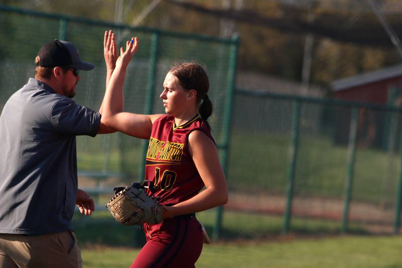 Richmond-Burton’s Hailey Holtz is greeted at the dugout in varsity softball at Marengo Monday.