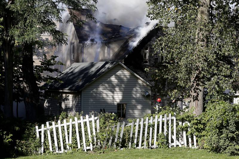 Firefighters battle a house fire in the 300 block of Lincoln Avenue in Woodstock Monday, Oct. 9, 2023, after an explosion following suspected gas leak in the area.