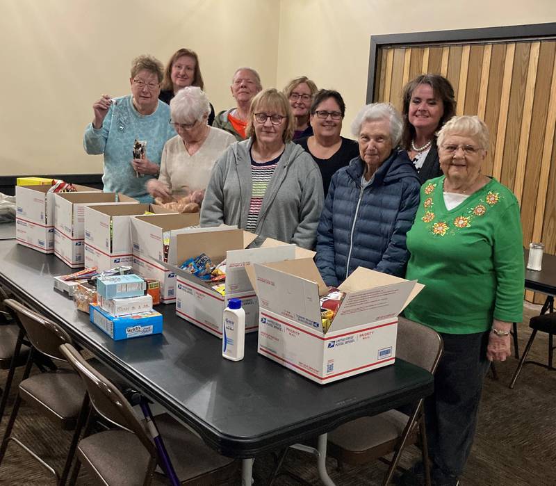 Members of the Streator Leading Ladies (left to right, front row) Donna Stone, Jean Sorensen, Jill Newbold, Gladys Perry and Carolyn Erler; (back row) Dianne O'Hern, Janna Rice, Lori Topolski, Dodi Callister and Kim Donner packed boxes for six servicemen they adopted.