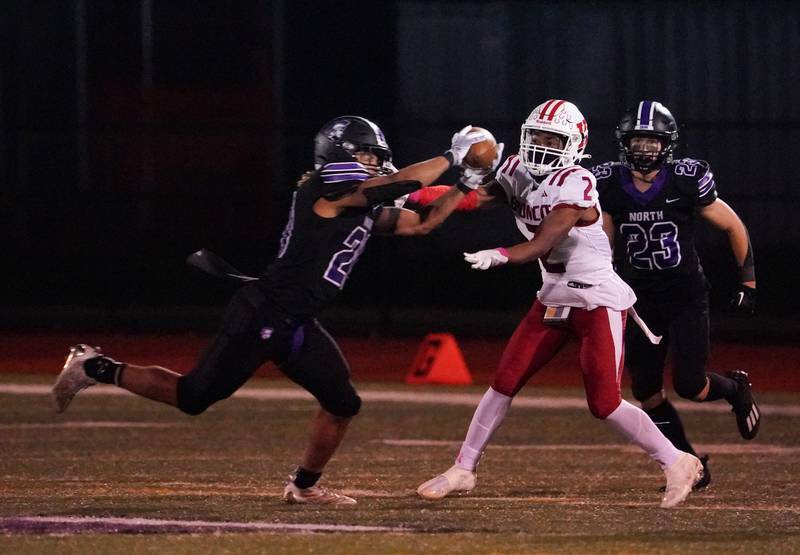 Downers Grove North's Noah Battle (20) intercepts a pass against Kenwood's Brain Searcy (2) during a class 7A playoff football game at Downers Grove North on Friday, Oct. 27, 2023.