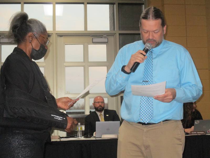 Jared Ploger, right, takes the oath of office after being appointed to the Oswego School District 308 board on April 11, 2022 at Oswego High School. Administering the oath is board President LaTonya Simelton, while district Superintendent John Sparlin looks on. (Mark Foster -- mfoster@shawmedia.com)