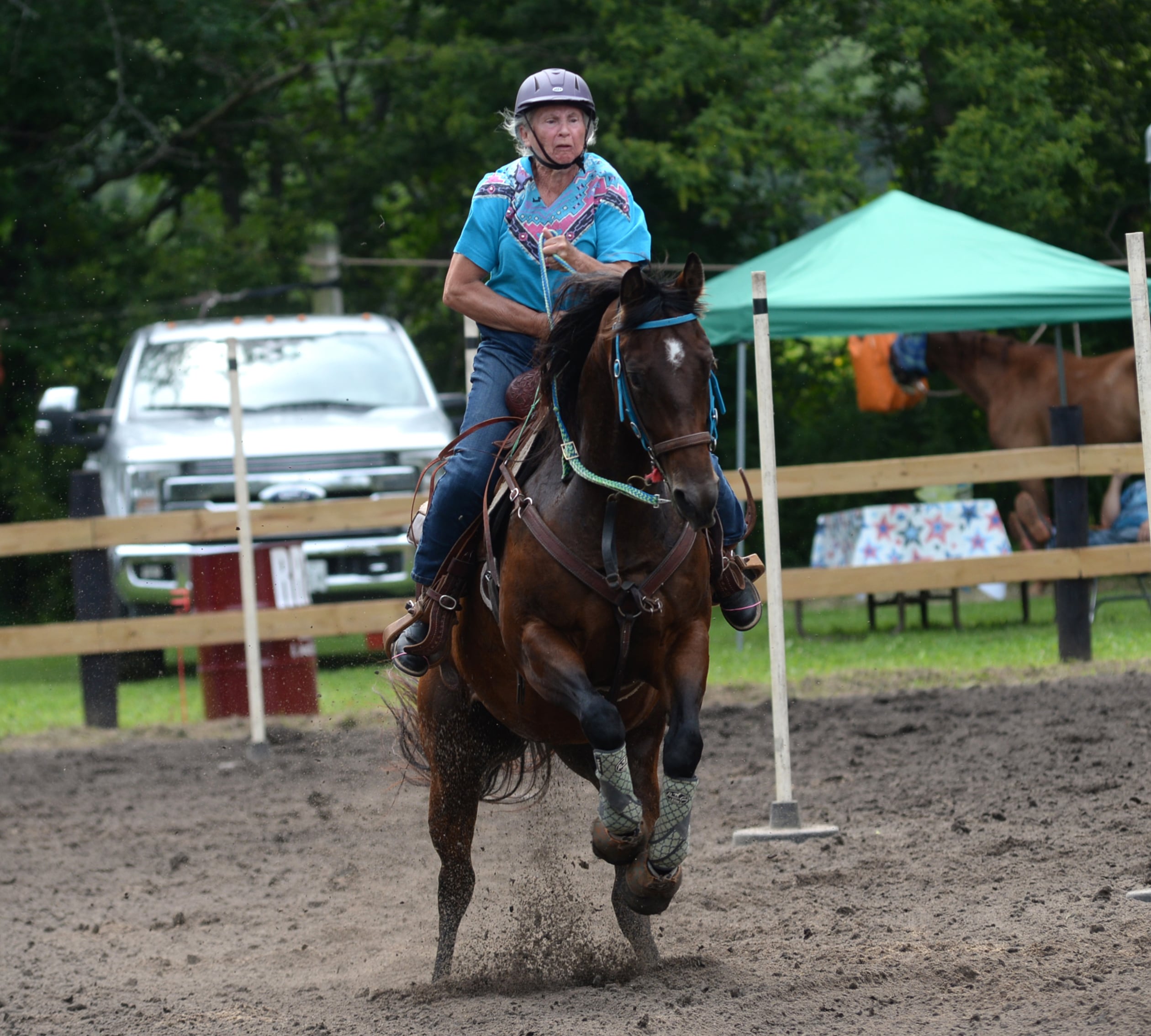 Ellen Inman, 75, of Davis Junction, navigates her horse, Heather, 6,  through the Poles Competition at the Rock River Trail & Horseman Association's Grand Opening Show on Saturday, July 20, 2024. Inman started competing in barrel racing when she was 60 after driving  her daughters and granddaughters to their competitions.