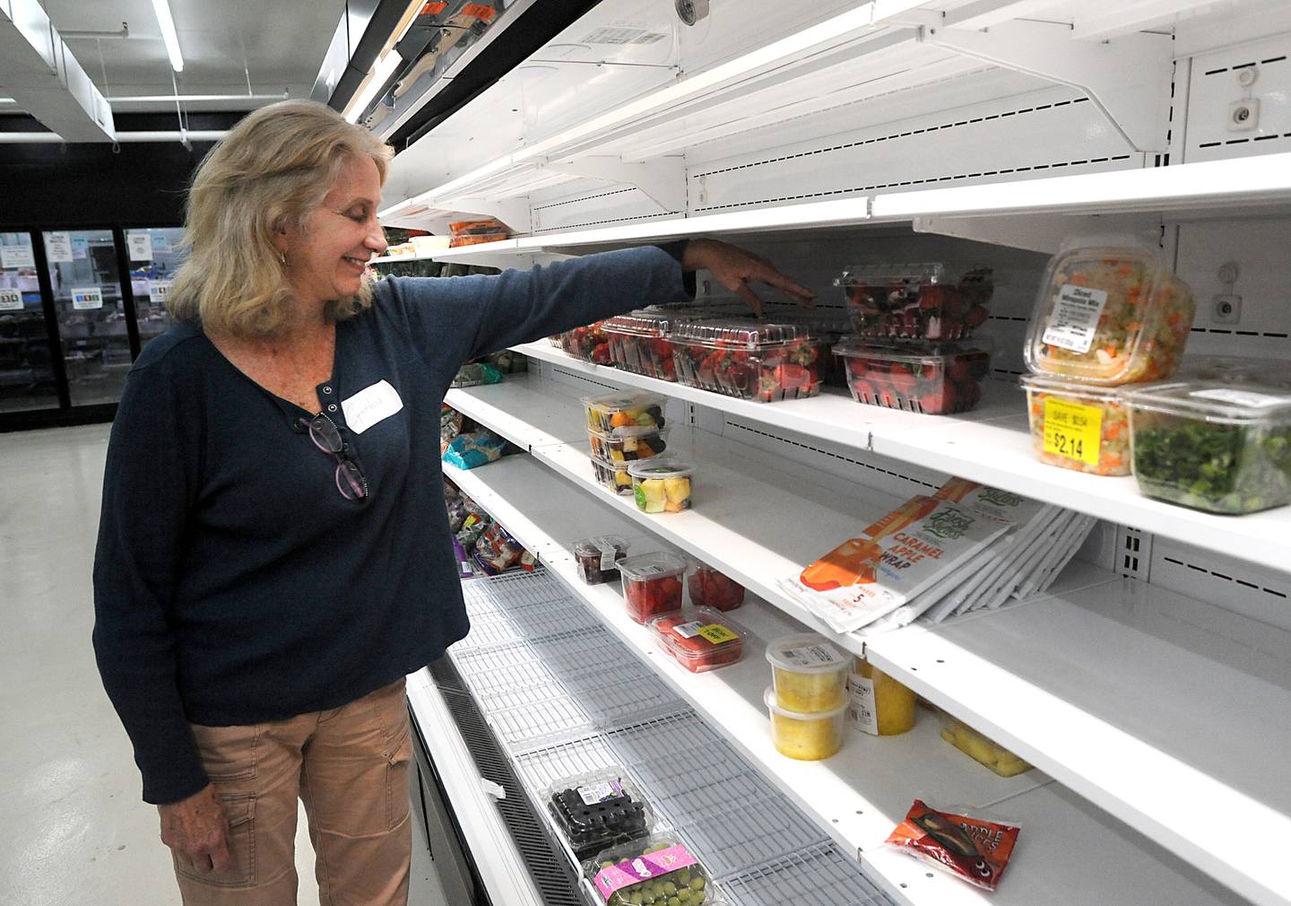 Volunteer Cynthia Bissell straightens up a shelf Monday, April 25, 2022, at the Crystal Lake Food Pantry, 42 East Street, in Crystal Lake. Food pantries across McHenry County are combating both inflation and increasing need.